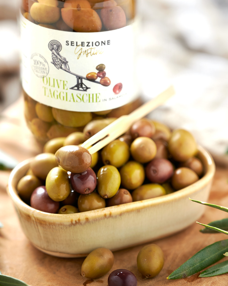 Taggiasca-Oliven in Salzlake – mit passenden Accessoires arrangiert