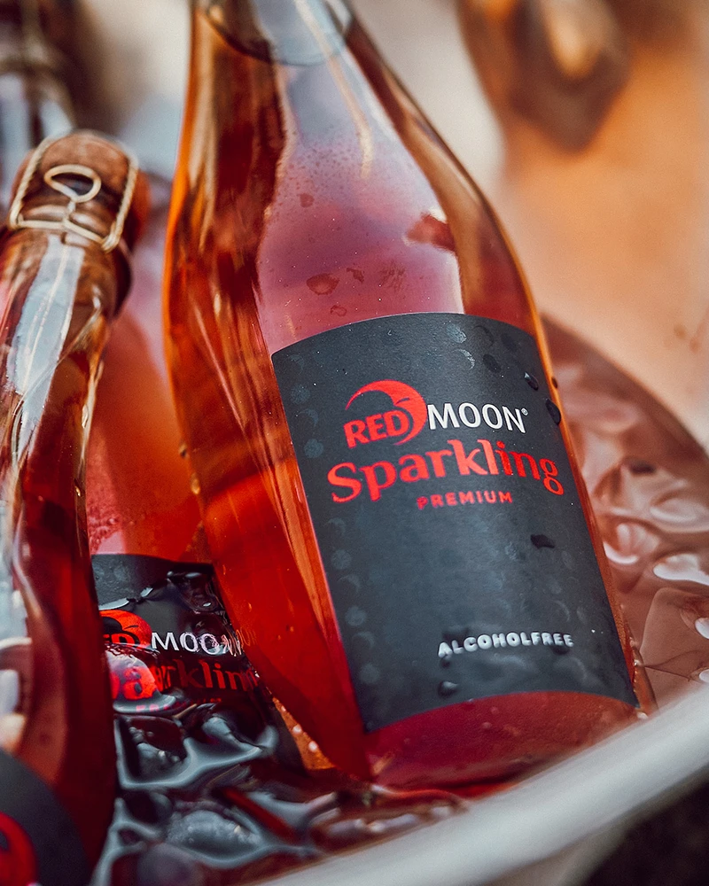 Red Moon 99.6 Sparkling - alkoholfrei – mit passenden Accessoires arrangiert