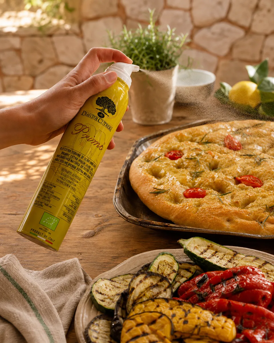 Bio-Olivenöl-Spray Primo von Frantoi Cutrera wird fein über Focaccia und gegrilltes Gemüse gesprüht.