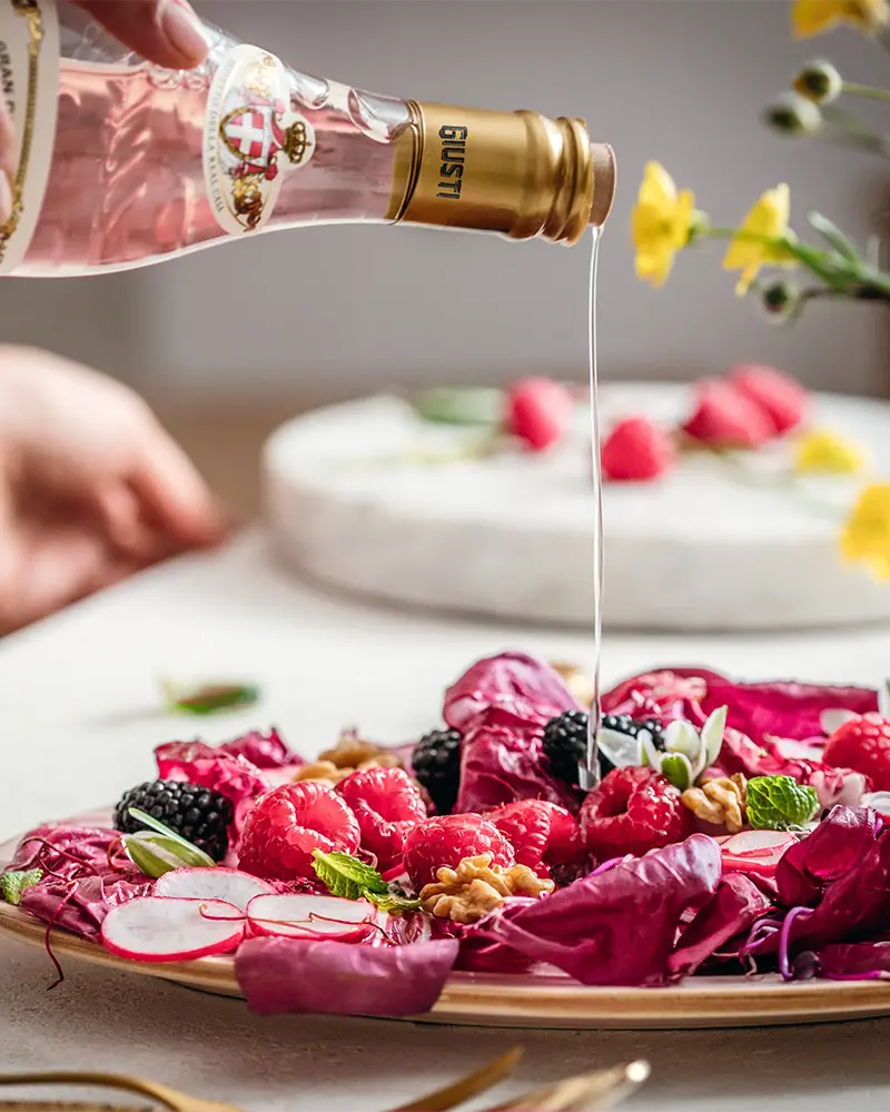 Giusti Agrodolce Rosato wird über Radicchiosalat mit Beeren, Radieschen und Walnüssen geträufelt.