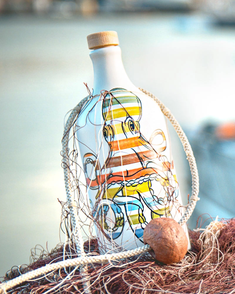 Muraglia Olivenöl - Tintenfisch Keramikflasche – Flasche im Hintergrund, in bunter Keramikflasche präsentiert