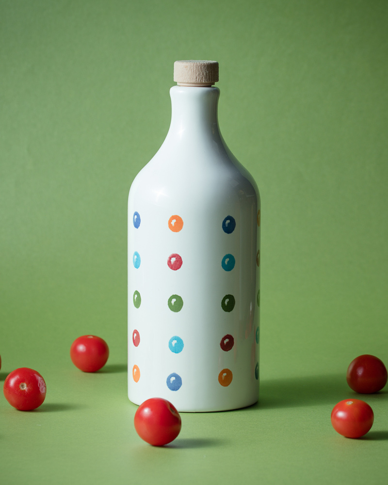 Muraglia Olivenöl - Punkte Keramikflasche – Flasche im Hintergrund, in bunter Keramikflasche präsentiert